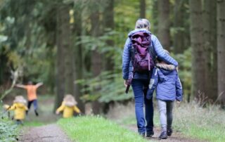 Grandmother with her grandchildren walking in the woods